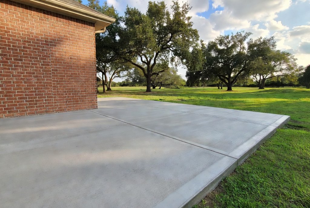 Fresh concrete patio behind a home with clean edges and control joints