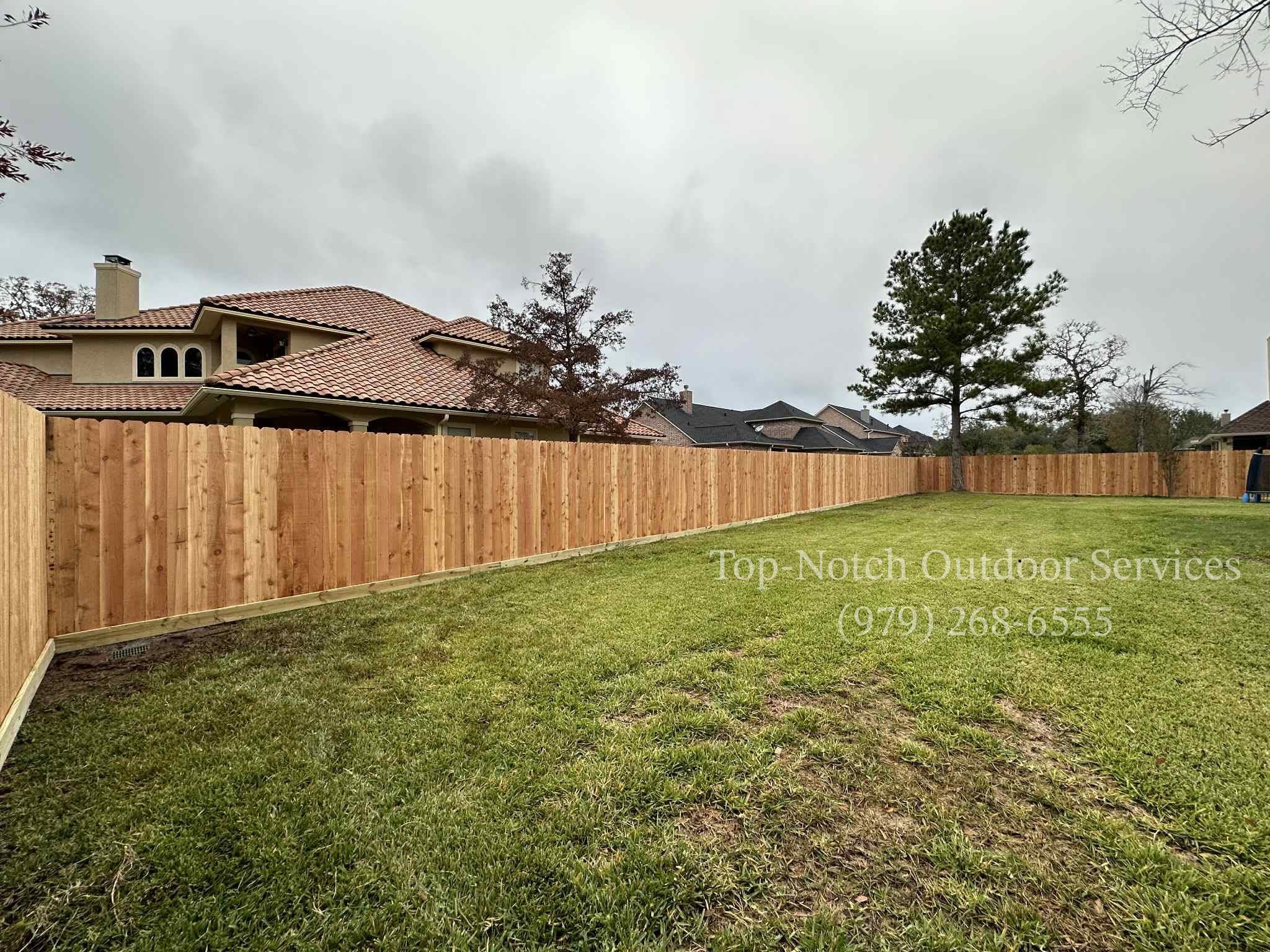 Cedar privacy fence along a manicured lawn