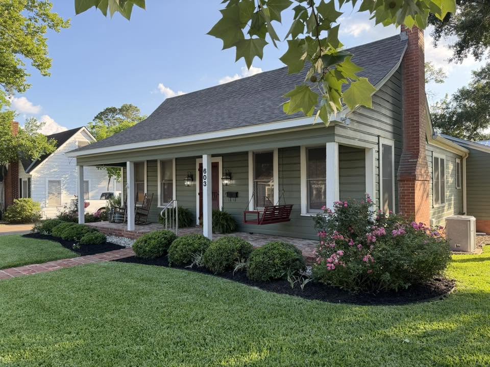 Freshly mowed lawn and manicured beds at a green cottage